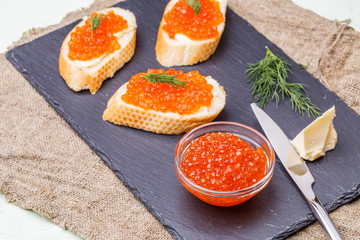 Baguette with salmon caviar, knife