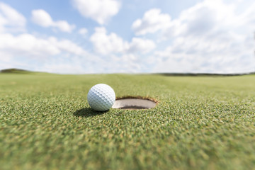 golf ball on lip of cup. Golf ball on green grass in golf course