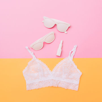 white accessories for stylish woman: lace bra, sunglasses and lipstick. pastel fashion minimalism