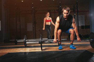 Fototapeta premium Group of sporty adults exercising with barbells