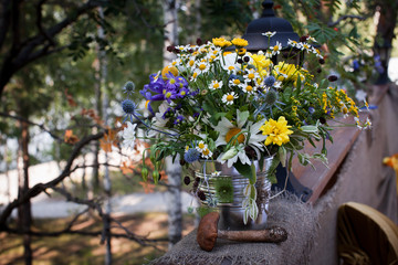 Fototapeta na wymiar Wildflowers in a metal bucket and mashroom near it