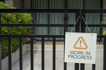 work in progress label on  town house front door fence at village