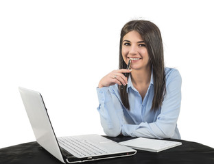 A cheerful young girl sitting in the office with a laptop and a pen. A white isolated background.