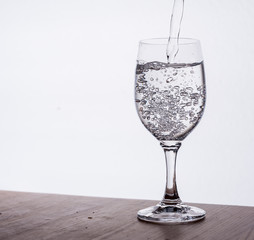 Wasserglas, voll vor hellem Hintergrund