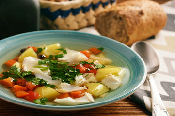 Clear fish soup with vegetables.