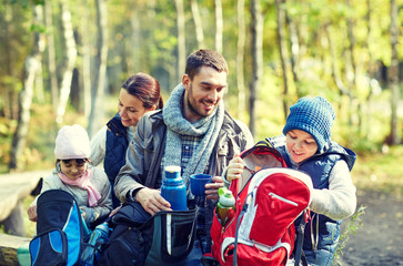 happy family with backpacks and thermos at camp
