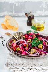 Vinegret.Traditsionny Russian and Ukrainian vegetable salad with beets, onions, potatoes, cucumbers and parsley. Selective focus.