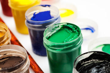 Macro shot of open gouache jars isolated on white