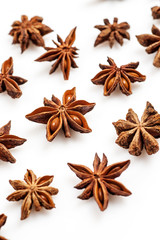 Close-up shot of star anise flat lay pattern isolated on white, vertical.