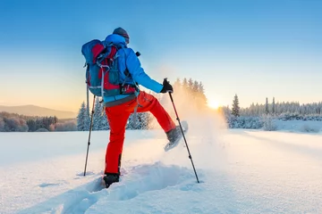 Poster Snowshoe walker running in powder snow © Jag_cz