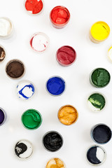 Open gouache jars on a white background, flat lay composition, top view, vertical