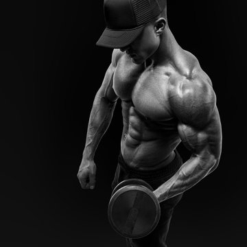 Athletic man bodybuilder lifting heavy dumbbells