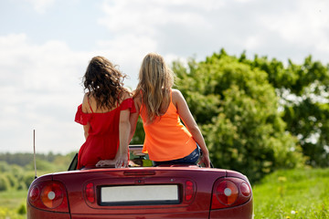 friends driving in convertible car at summer 