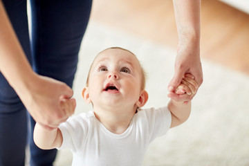 happy baby learning to walk with mother help