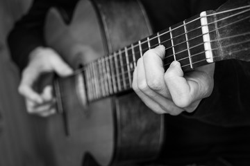 Fototapeta na wymiar Man playing classical guitar. Black and white photo.