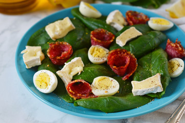 Salad with spinach, brie cheese and quail eggs 
