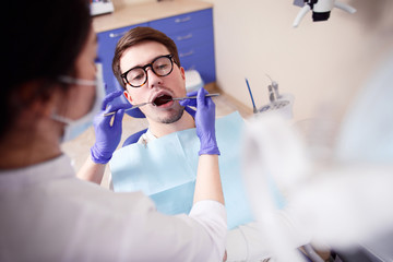 Confident woman dentist treats teeth patient in hospital