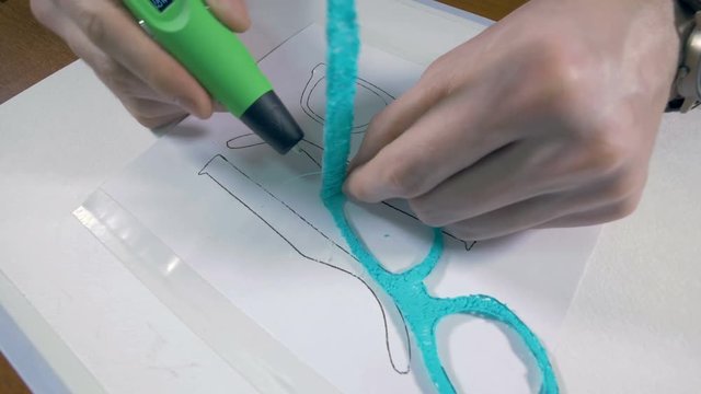 Man fabricating glasses made with 3D printing pen. 4K.