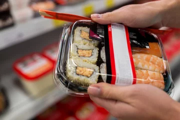Crédence de cuisine en verre imprimé Bar à sushi hands with sushi pack at grocery or supermarket