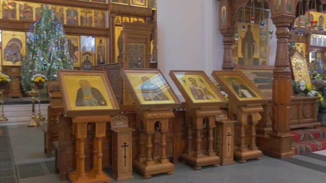 a Number of Beautiful Old Icons on Wooden Stands Inside of an Orthodox Christian Cathedral With a Splendid Iconostasis in the Background