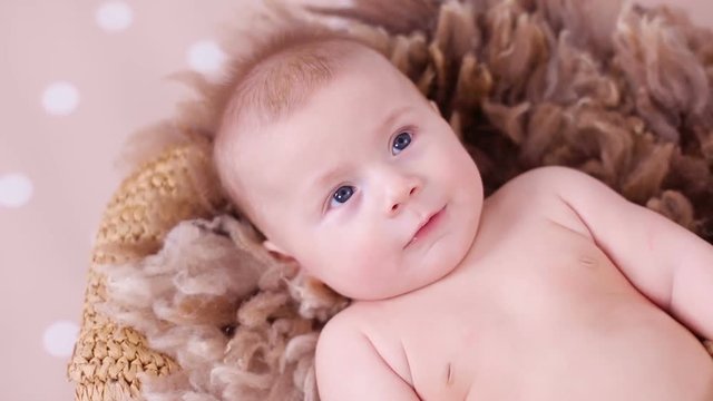 naked baby boy lying on a brown wool background with polka dot