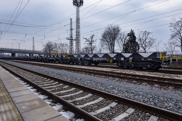 Obraz premium Burgas, Bulgaria - January 24, 2017 - Freight cargo train - black cars wagons - New 6-axled flat wagon - Type: Sahmmn - Model WW 604 A - Transvagon AD