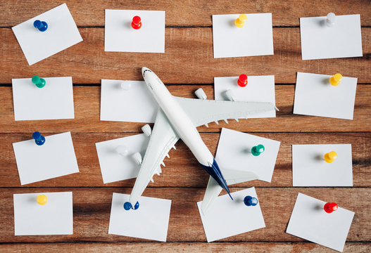Preparation for Traveling concept and to do list, the paper noted, airplane, colorful push pin, on a vintage wooden background with copy space.