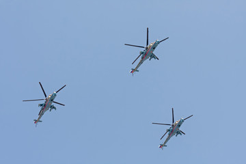 Mi-24 (Hind) large gunship and attack helicopters and low-capacity troop transportы fly against blue sky background
