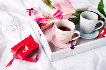tray with cup of hot tea in the bed,