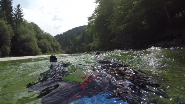 FPV: Group of friends descending down the river rapid floating on water surface