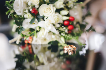 Obraz na płótnie Canvas Two Golden Wedding Rings on flowers macro shot