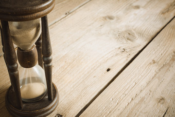 Old hourglass on wooden table