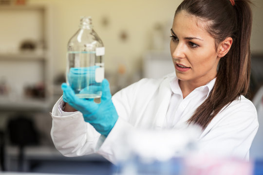 A skilled female lab scientist, deeply engrossed in her work, conducts precise chemical experiments and research, contributing to scientific advancements.