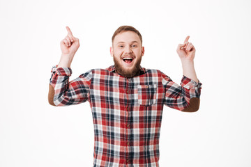 Fototapeta premium Laughing Bearded man in shirt pointing up
