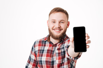 Bearded man in shirt showing blank smartphone screen at camera