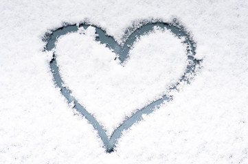 Heart for valentine drawn on a car windshield covered with fresh snow.