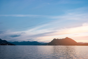 Water, hills and sky. Mountains and town at distance. Lake Maggiore in summer.