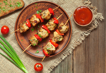 Traditional delicious turkey shish kebab skewer barbecue meat with tomatoes, pepper and sauce on ceramic dish. Served on wooden table background. Rustic style, natural light. Picnic bbq gourmet.
