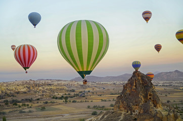 Fototapeta na wymiar Colorful hot air balloons flying over the valley at Cappadocia, Turkey. Volcanic mountains in Goreme national park