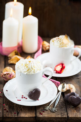 Hot Tea or Chocolate in White Cups with Chocolate Hearts and Lit Candles on Wooden Rustic Background, Valentines Day Concept