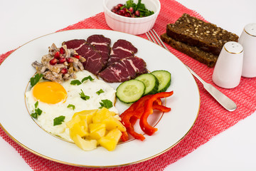 Fried egg with vegetables and a side dish of potatoes with mushr