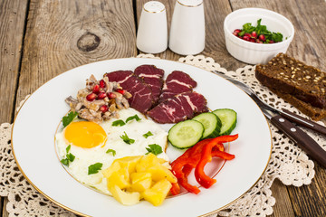 Fried egg with vegetables and a side dish of potatoes with mushr