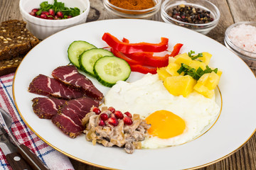 Fried egg with vegetables and a side dish of potatoes with mushr