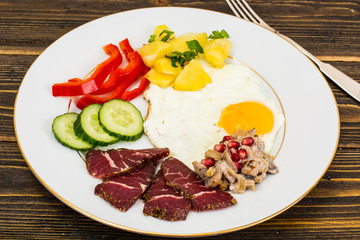 Fried egg with vegetables and a side dish of potatoes with mushr