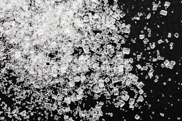 White sugar on a black background, top view.