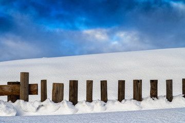 Snow-covered wooden fence