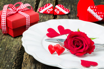 Fototapeta na wymiar Valentinstag, Gedeck mit Rose, Herzen und Geschenk