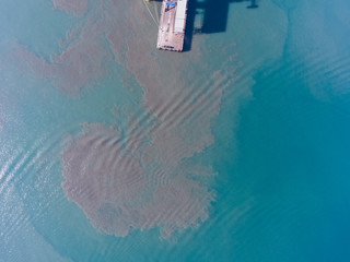 View of the dirt in the water near the pier at the port.