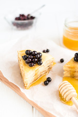 Homemade pancakes with berries and honey on a white background
