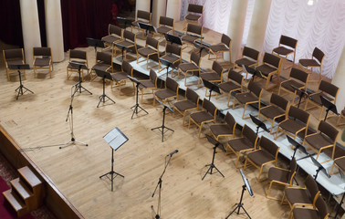 Empty stage with chairs, microphones and music stands before the